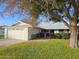 Ranch style home with attached two-car garage and mature landscaping at 10113 W Kingswood Cir, Sun City, AZ 85351