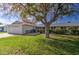 House exterior showcasing a large yard and mature tree at 10113 W Kingswood Cir, Sun City, AZ 85351