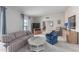 Living room featuring a plaid couch, blue armchair, and a wood cabinet at 10845 W Kaibab Dr, Sun City, AZ 85373