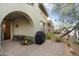 Backyard patio area with an arched doorway attached to the house and desert landscaping at 20802 N Grayhawk Dr # 1087, Scottsdale, AZ 85255