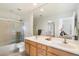 Bathroom featuring dual sinks, a large mirror, and a shower/tub combination with sliding glass doors at 20802 N Grayhawk Dr # 1087, Scottsdale, AZ 85255