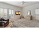 Bright bedroom featuring shuttered windows, a ceiling fan, and a sitting area at 20802 N Grayhawk Dr # 1087, Scottsdale, AZ 85255