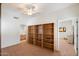 Bedroom view showcasing built-in shelving, neutral carpeting, and open doorway to bathroom at 20802 N Grayhawk Dr # 1087, Scottsdale, AZ 85255