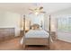 A bright bedroom featuring a four-poster bed, neutral walls, a ceiling fan, and plantation shutters at 20802 N Grayhawk Dr # 1087, Scottsdale, AZ 85255