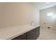 Laundry room with quartz countertop and dark cabinets at 21951 E Misty Ln, Queen Creek, AZ 85142