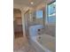 Main bathroom with a soaking tub, walk-in shower, and marble tile at 33333 N 132Nd Dr, Peoria, AZ 85383