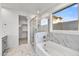 Bathroom with marble tile, bathtub, and shower at 33333 N 132Nd Dr, Peoria, AZ 85383