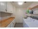 Functional laundry room with built-in cabinets and wood countertop at 4053 E Glencove St, Mesa, AZ 85205