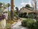 Landscaped backyard oasis with cacti, a paved pathway, and a view of the home at 61 W Wilshire Dr, Phoenix, AZ 85003