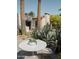 Outdoor patio with white table and chairs, nestled amongst desert plants at 61 W Wilshire Dr, Phoenix, AZ 85003