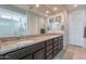 Double vanity bathroom with granite countertops and large mirrors at 7067 W Maya Way, Peoria, AZ 85383