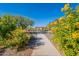 Pathway through a community with yellow flowers and a gazebo at 7067 W Maya Way, Peoria, AZ 85383