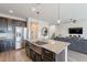 Modern kitchen with dark cabinets, granite countertops, and island at 7067 W Maya Way, Peoria, AZ 85383