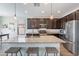 Modern kitchen with dark cabinets, granite countertops, and island at 7067 W Maya Way, Peoria, AZ 85383