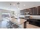 Modern kitchen with dark cabinets, granite countertops, and island at 7067 W Maya Way, Peoria, AZ 85383