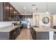 Modern kitchen with dark cabinets, granite countertops, and island at 7067 W Maya Way, Peoria, AZ 85383