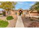 A walkway leads to the entrance of a charming tan house with stone accents at 7710 E Monica Dr, Scottsdale, AZ 85255