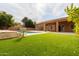 A refreshing pool in a backyard with artificial turf and mature trees at 7710 E Monica Dr, Scottsdale, AZ 85255