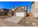 Two-story house with a white garage door and brown accents at 9242 E Sector Dr, Mesa, AZ 85212