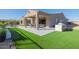 Spacious backyard with artificial turf, covered patio, and outdoor kitchen at 13271 E Desert Vista Rd, Scottsdale, AZ 85255