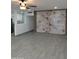 Open living room features a ceiling fan, tile floors, and a statement wall with wood trim accents at 102 W Maryland Ave # F1, Phoenix, AZ 85013