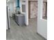 View of the open floor plan with a kitchen with modern appliances and a statement wall in the living room at 102 W Maryland Ave # F1, Phoenix, AZ 85013