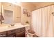 Clean bathroom with a shower/tub combo, dark vanity and a white curtain at 21655 N 36Th Ave # 117, Glendale, AZ 85308