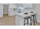 White kitchen with modern fixtures, stainless steel appliances, and breakfast bar at 2364 W Emelita Ave, Mesa, AZ 85202