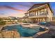 Stunning backyard oasis with a rock-rimmed pool, spa, covered patio, and manicured landscaping for relaxing outdoors at 3428 N Park St, Buckeye, AZ 85396