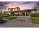 Elegant two-story home featuring stone accents, a porte cochere, and a meticulously landscaped front yard at 3428 N Park St, Buckeye, AZ 85396