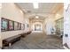 Interior hallway with neutral colors, benches, display boards, and views towards the entrance at 14426 W Gunsight Dr, Sun City West, AZ 85375