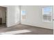 Bright bedroom with neutral carpeting and two large windows at 53275 W Adele Rd, Maricopa, AZ 85139