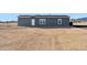 Gray manufactured home with large lot in desert setting at 53275 W Adele Rd, Maricopa, AZ 85139