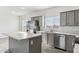 Modern kitchen with gray cabinets, stainless steel appliances, and an island at 53275 W Adele Rd, Maricopa, AZ 85139