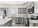 Modern kitchen featuring gray cabinets, stainless steel appliances, and an island at 53275 W Adele Rd, Maricopa, AZ 85139