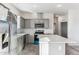 Modern kitchen with gray cabinets, island, and stainless steel appliances at 53275 W Adele Rd, Maricopa, AZ 85139