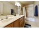 Well-lit bathroom featuring a dual sink vanity, tiled shower, and a full bathtub at 5951 E Trailridge St, Mesa, AZ 85215
