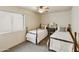 Cozy bedroom featuring twin beds, a ceiling fan and natural light from a large window at 5951 E Trailridge St, Mesa, AZ 85215