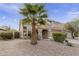 Tan two-story house with a palm tree and gravel landscaping at 5951 E Trailridge St, Mesa, AZ 85215
