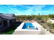 Aerial view of a backyard featuring a modern pool, spa, artificial turf and desert landscaping at 8714 E Tether Trl, Scottsdale, AZ 85255