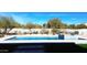 Fenced-in backyard featuring a modern pool, spa, artificial turf, and desert landscaping at 8714 E Tether Trl, Scottsdale, AZ 85255