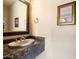 Powder room with dark marble vanity and decorative mirror at 11714 N 134Th St, Scottsdale, AZ 85259
