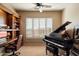 Home office features built-in shelving, a large window, and a grand piano at 11714 N 134Th St, Scottsdale, AZ 85259