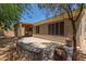 Backyard featuring a covered patio, desert landscaping, and a stucco exterior at 1231 W Hawken Way, Chandler, AZ 85286