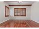 Bedroom featuring wood floors, a ceiling fan, and windows with wooden shutters at 1231 W Hawken Way, Chandler, AZ 85286