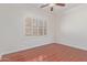 Bedroom featuring wood floors, a ceiling fan, and windows with shutters at 1231 W Hawken Way, Chandler, AZ 85286