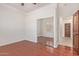 Bedroom featuring wood floors, a mirrored closet, and wood door at 1231 W Hawken Way, Chandler, AZ 85286