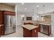 Spacious kitchen featuring stainless steel appliances and a center island with a sink and faucet at 1231 W Hawken Way, Chandler, AZ 85286