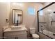 Modern bathroom boasts marble counters, sleek fixtures, a vessel sink, and a glass-enclosed shower-tub combination at 21165 W Carver Rd, Buckeye, AZ 85326