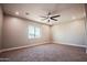 Bright and spacious bedroom with a large window, ceiling fan, and plush carpet at 21165 W Carver Rd, Buckeye, AZ 85326